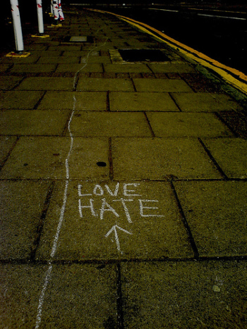"love hate" and an arrow (this way!) written on a sidewalk