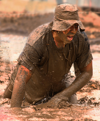 a guy slogs through thigh-deep mud